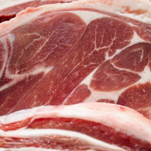 Detailed close-up of raw lamb chops showing marbling and texture.